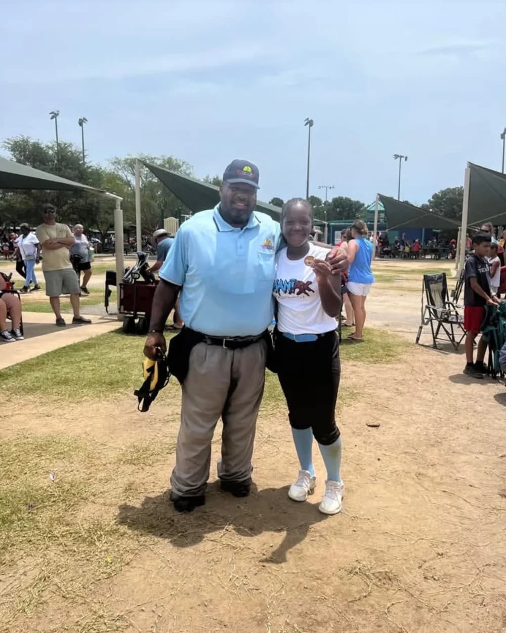 Kennedi Fair with a MVP World Series softball coach at a camp.
